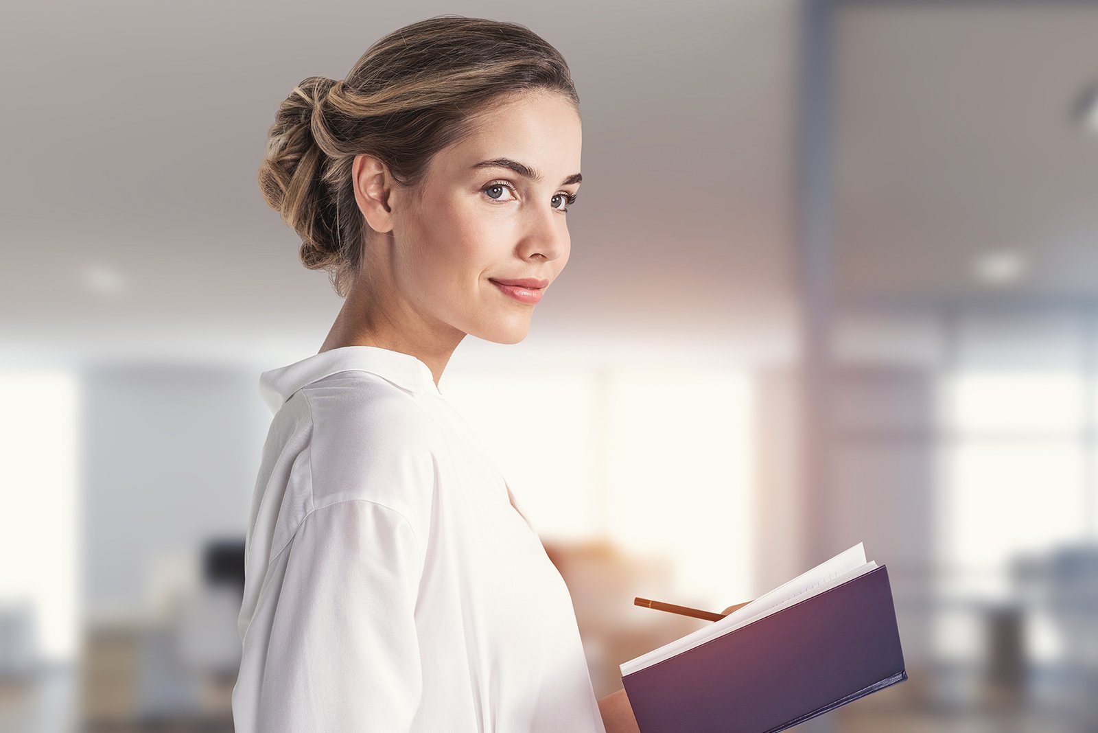 Female adult teacher holding a notebook, looking off in the distance